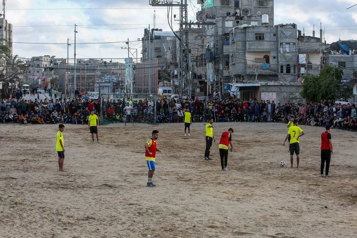 Jovens jogam futebol na Faixa de Gaza sitiada [Abed Rahim Khatib/Agência Anadolu]