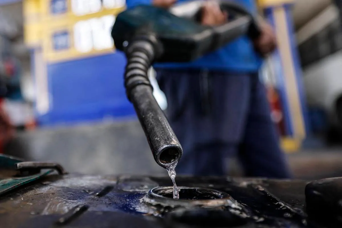 Trabalhador enche o tanque de um veículo em um posto de gasolina no Cairo, em 2 de março de 2023, em meio a um novo aumento nos preços dos combustíveis anunciado pelo governo [Khaled Desouki/AFP via Getty Images]
