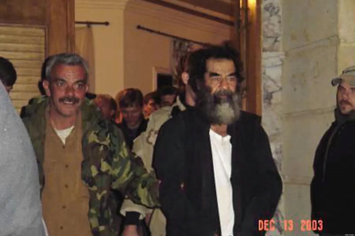 Líder iraquiano Saddam Hussein em um local desconhecido no Iraque após sua captura pelas tropas americanas em 13 de dezembro de 2003 de um buraco subterrâneo em uma fazenda na vila de ad-Dawr, perto de sua cidade natal, Tikrit, no norte do Iraque [Getty Images]