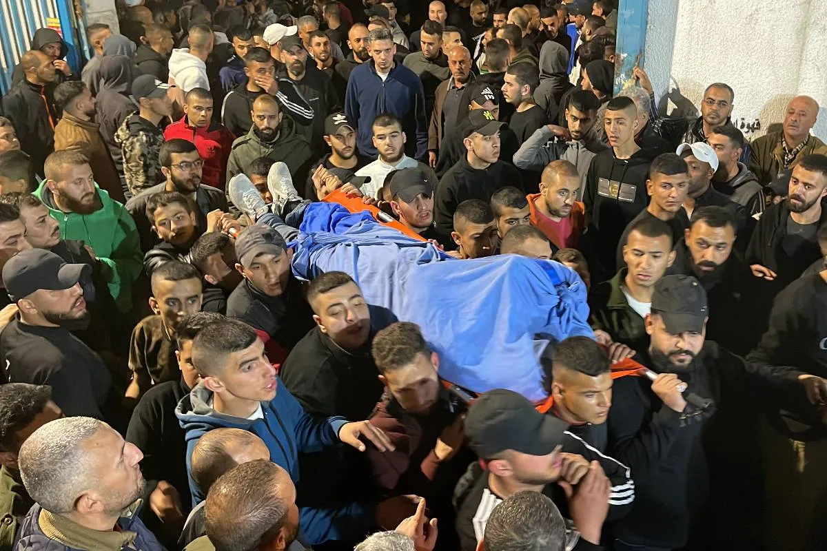 Palestinos carregam corpos de palestinos mortos por fogo israelense durante ataque militar na terça-feira no Cisjordânia, cidade de Jenin [Hisham K. K. Abu Shaqra/ Agência Anadolu]
