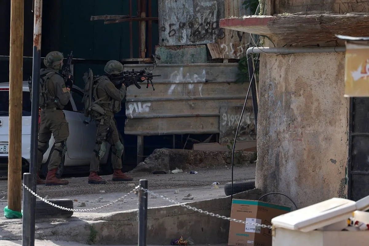 Tropas israelenses se posicionam no campo de refugiados palestinos de Nur Shams, perto da cidade de Tulkarem, no norte da Cisjordânia. [Foto de Jaafar Ashtiyeh/AFP via Getty Images] 
