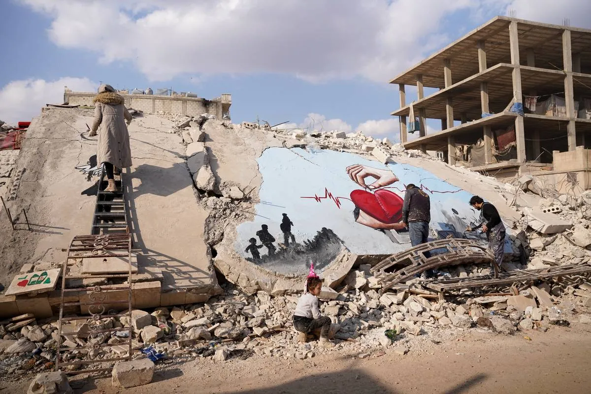 Artistas sírios Aziz Asmar, Salam Hamid e Muhammad Enis Hamdun pintam temas de sobrevivência nos escombros deixados pelo terremoto em Aleppo na Síria, em 22 de fevereiro de 2023 [Ömer Alven/Agência Anadolu]