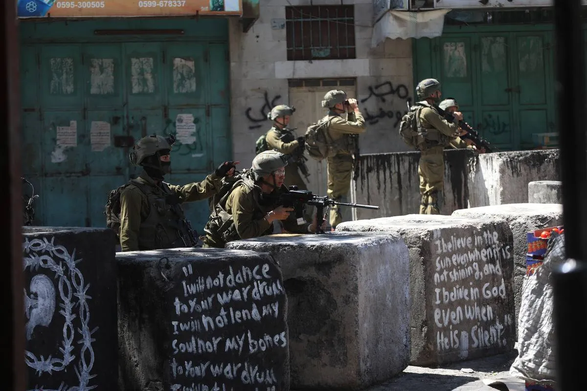 Soldados israelenses reprimem protesto palestino após a morte em custódia de Khader Adnan, prisioneiro em greve de fome, em Hebron (Al-Khalil), na Cisjordânia ocupada, em 2 de maio de 2023 [Mamoun Wazwaz/Agência Anadolu]
