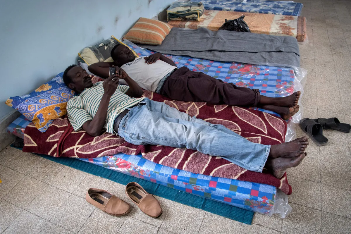 Refugiados sudaneses, que fugiram da violência entre forças leais ao Governo de Acordo Nacional (GNA)e forças leais a Khalifa Haftar, descansam em uma escola na capital da Líbia, Trípoli, em 24 de abril de 2019 [Fadel Senna/Getty]
