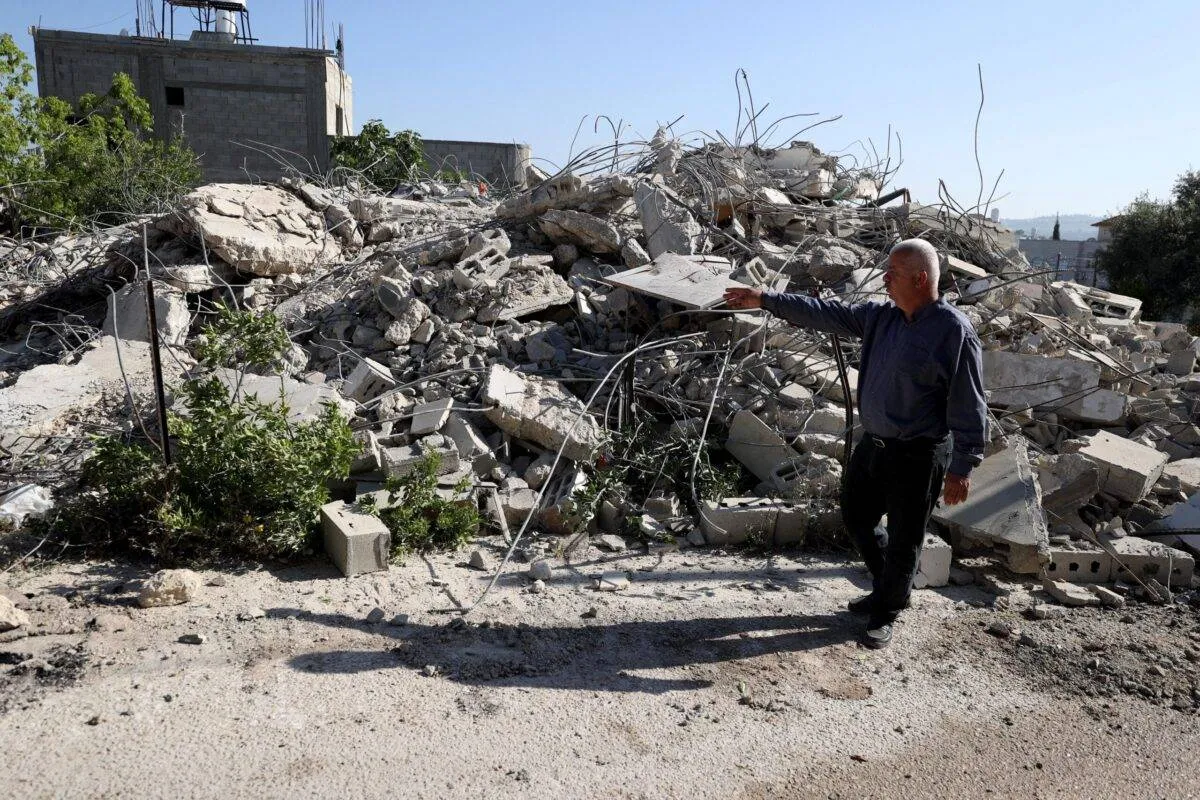 Homem vasculha local onde  máquinas pesadas das forças israelenses demoliram uma casa palestina em Qalqilya, Cisjordânia, em 3 de abril de 2023 [Issam Rimawi/Agência Anadolu via Getty Images]
