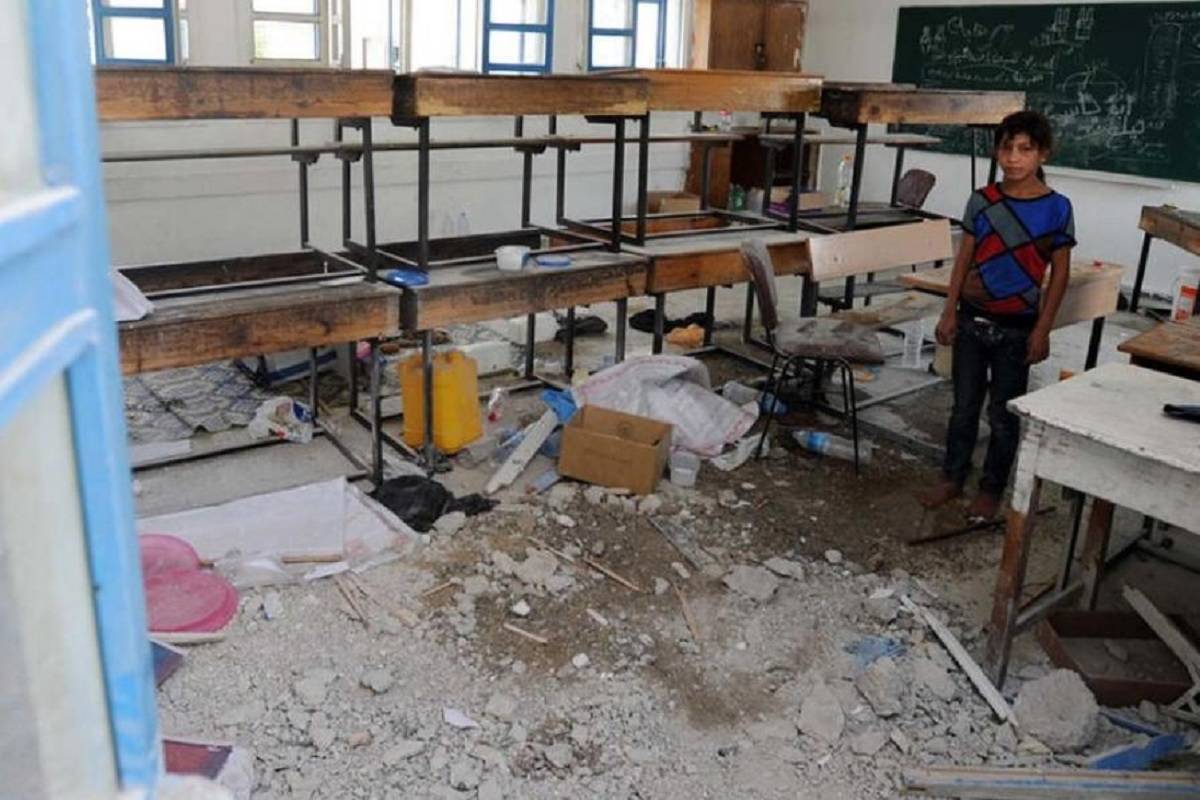 Legenda: Um estudante palestino inspeciona os danos em uma escola da ONU em Gaza. [Arquivo/ONU ]