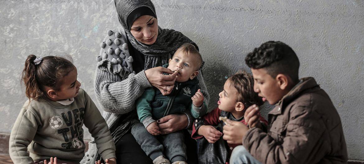 Uma família palestiniana em Gaza partilha uma refeição comprada com um vale alimentar do PAM. [Ali Jadallah /WFP]