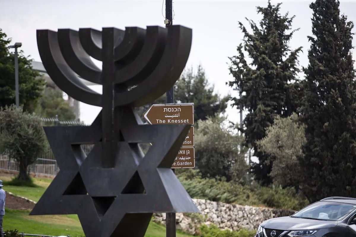 Placa indica direção do parlamento israelense (Knesset), em Jerusalém ocupada, em 6 de julho de 2021 [Mostafa Alkharouf/Agência Anadolu]