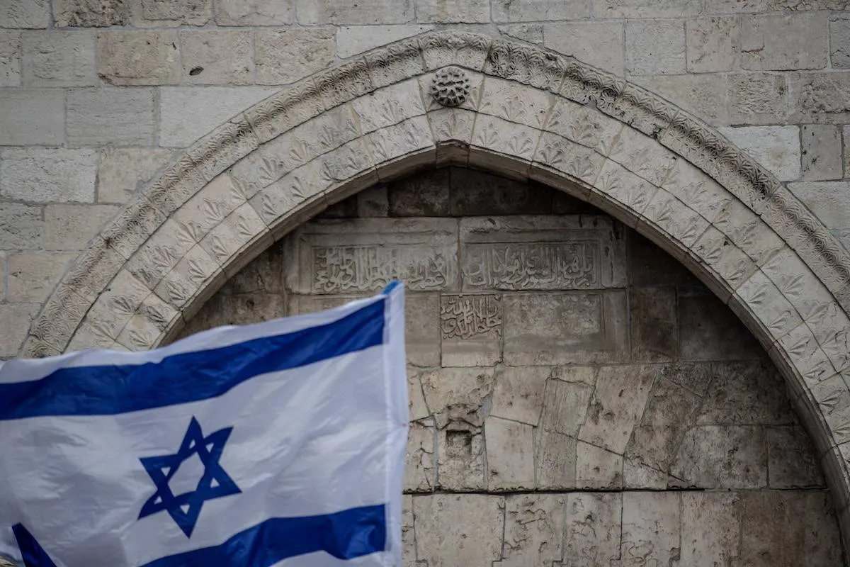 Colonos judeus fanáticos segurando bandeiras israelenses participam de uma marcha anual do dia da bandeira passando pelo Portão de Damasco até a Cidade Velha de Jerusalém [Mostafa Alkharouf /Agência Anadolu]
