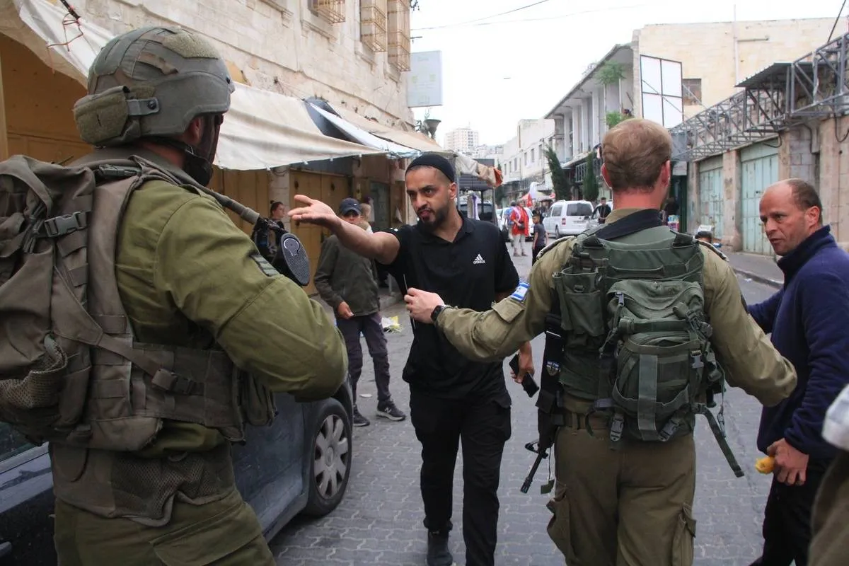 Colonos israelenses sob escolta militar invadem Hebron (Al-Khalil), na Cisjordânia ocupada, em 27 de maio de 2023 [Amer Shallodi/Agência Anadolu]
