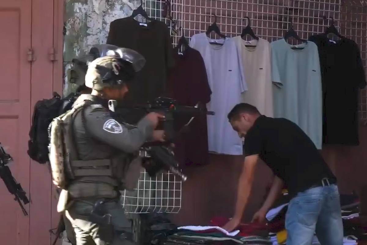 Colonos invadiram uma área de Hebron sob escolta militar israelense; soldados apontaram armas a lojistas palestinos para obrigá-los a fechar as portas
