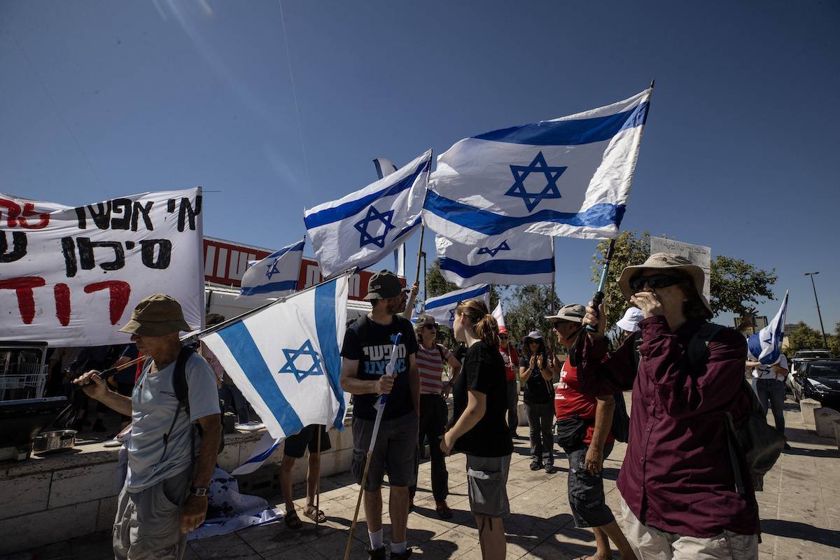 Manifestantes se reúnem em frente ao Supremo Tribunal de Israel antes da sessão em que o pedido de anulação da lei, que foi aprovado pelo parlamento israelense em março, e transferiu a autoridade para demitir o primeiro-ministro do Procurador-Geral e do Supremo Tribunal, ao Parlamento e ao governo em Jerusalém, em 3 de agosto de 2023 [Mostafa Alkharouf – Agência Anadolu]
