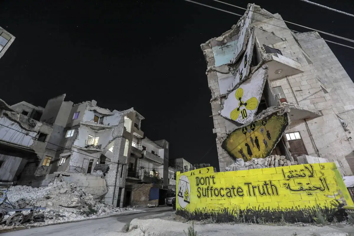 Murais reivindicam justiça pelo ataque químico a Ghouta em escombros de Idlib, no norte da Síria, em 20 de agosto de 2023 [Izzeddin Kasim/Agência Anadolu]
