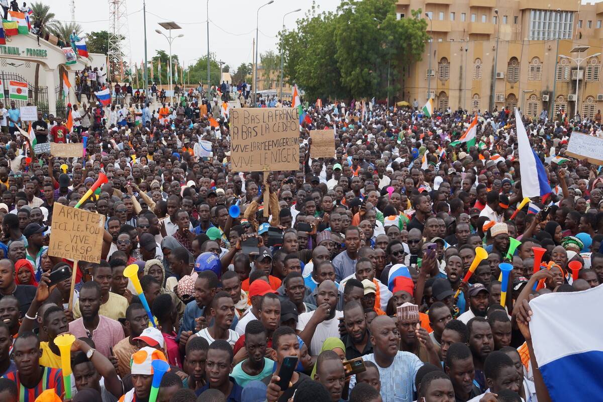 Apoiadores do golpe agitam bandeiras durante o protesto contra uma possível intervenção militar do bloco e sanções da Comunidade Económica dos Estados da África Ocidental (Cedeao) em Niamey, Níger, em 20 de agosto de 2023 [Balima Boureima/Agência Anadolu]
