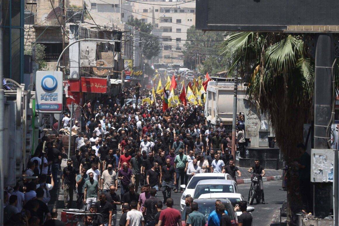 Pessoas assistem ao funeral de 10 palestinos mortos durante os ataques aéreos e ataques israelenses sobre o campo de refugiados de Jenin em Jenin, Cisjordânia, em 5 de julho de 2023 [Issam Rimawi/Agência Anadolu]
