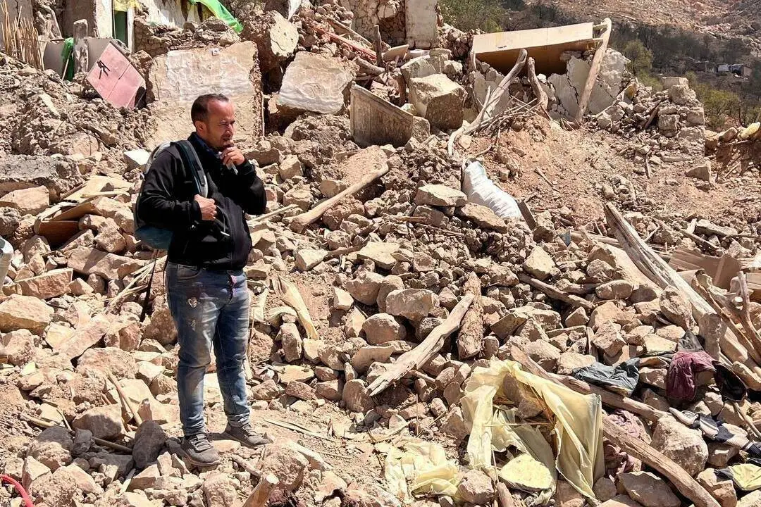Um homem é visto entre os escombros de edifícios desabados enquanto os esforços de busca e resgate continuam após o terremoto de magnitude 7 na cidade de Boulemane, em Ait Othmane, Marrocos, em 12 de setembro de 2023 [Said Echarif/Agência Anadolu]


