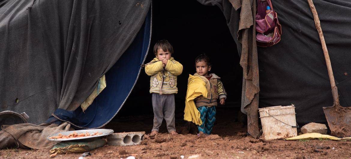 Crianças deslocadas em frente à tenda da sua família num campo informal no sul da Síria [/Hasan Belal/unicef]