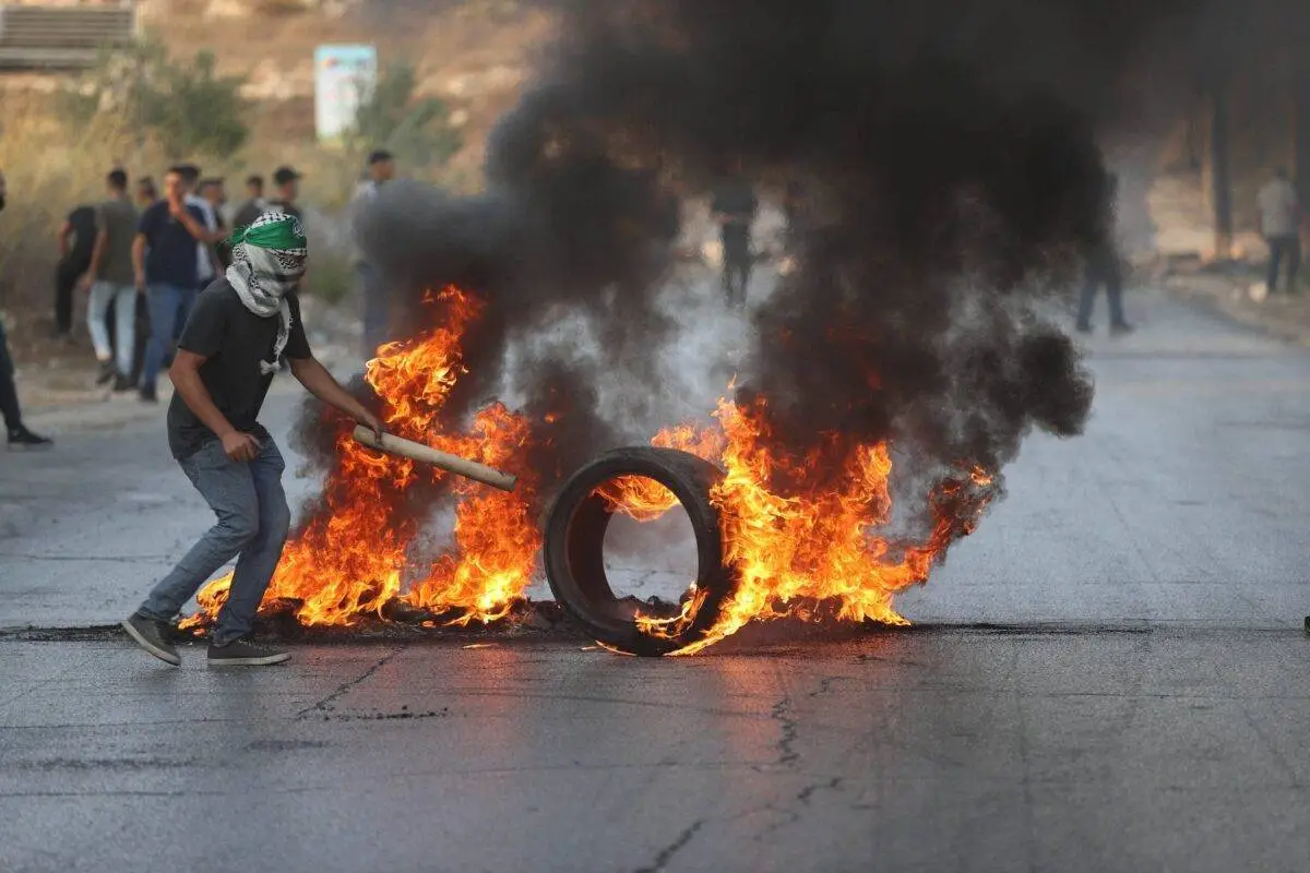 Protesto contra os ataques israelenses a Gaza perto de um checkpoint militar em Ramallah, na Cisjordânia ocupada, 8 de outubro de 2023 [Issam Rimawi/Agência Anadolu]
