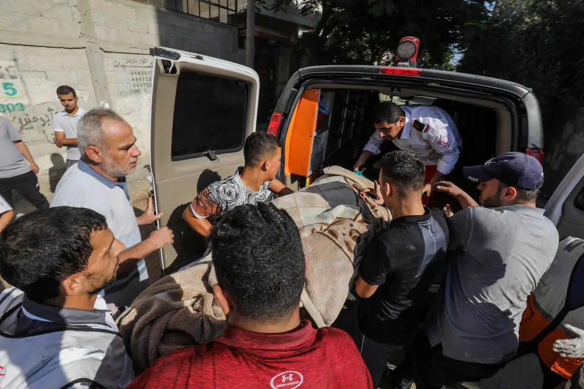 Membros da defesa civil e moradores realizam operação de busca e resgate em meio a escombros e prédios destruídos após os ataques aéreos israelenses continuarem no sétimo dia em Rafah, Gaza, em 13 de outubro de 2023 [Abed Rahim Khatib - Anadolu Agency]
