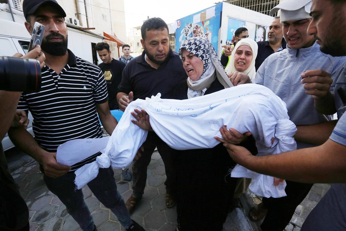Uma mulher carrega o cadáver de uma criança para o necrotério do Hospital Suheda al-Aqsa (Hospital dos Mártires de Al-Aqsa) enquanto os ataques de Israel à Faixa de Gaza continuam em seu 8º dia em Deir al-Balah, Gaza, em 14 de outubro de 2023 .
[Ashraf Amra/Anodolu]