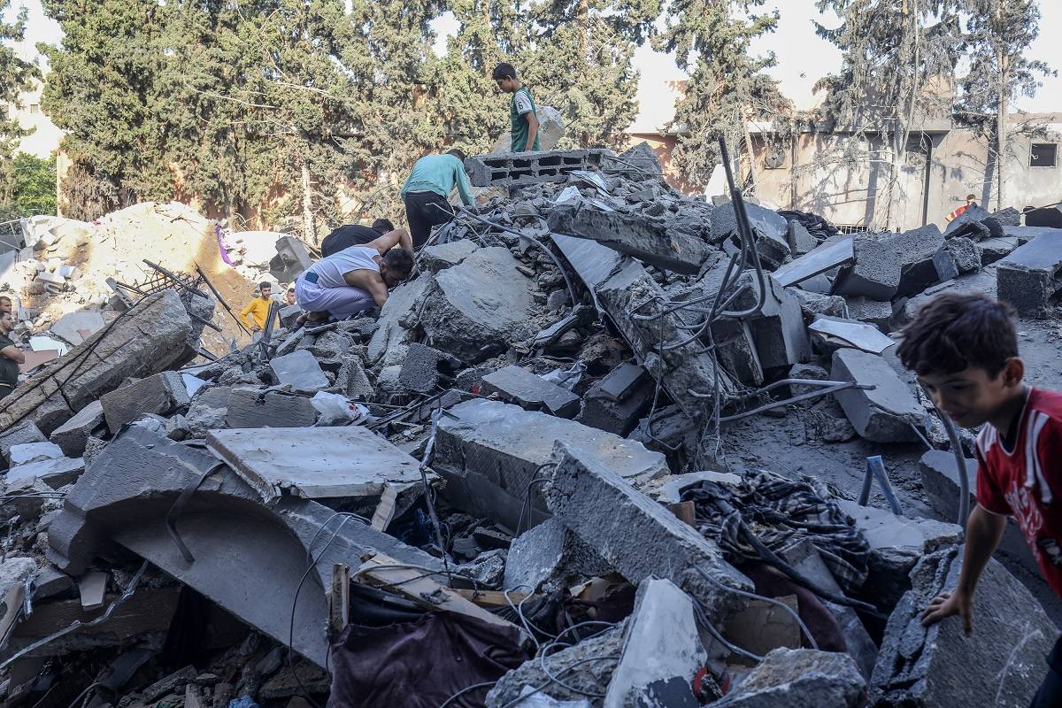 Equipes de defesa civil e residentes lançam uma operação de busca e resgate ao redor da casa da família Tahravi que foi destruída após os ataques de Israel à Faixa de Gaza em seu oitavo dia em Rafah, Gaza, em 14 de outubro de 2023.
[Abed Rahim Khatib/Anadolu]