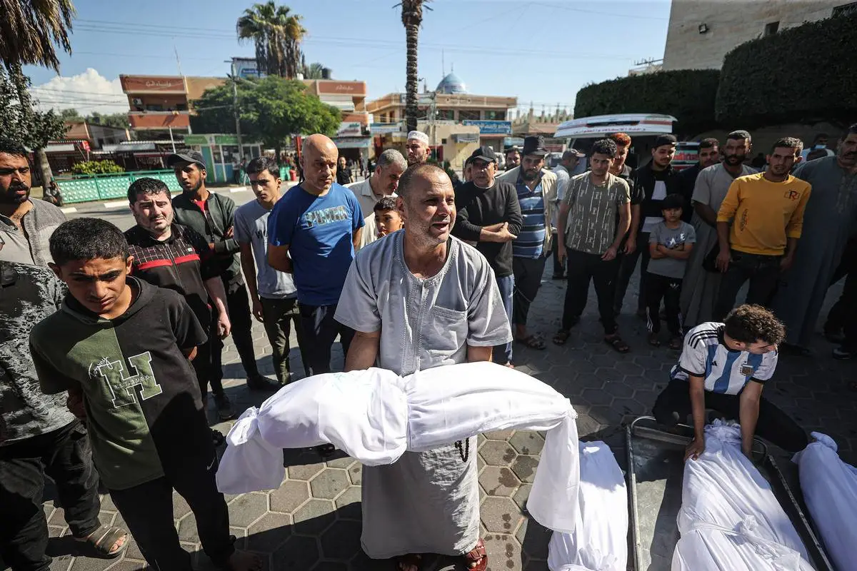 Corpos de palestinos mortos em ataques aéreos israelenses foram retirados do necrotério do Hospital Aqsa para serem enterrados em Deir Al-Balah, Gaza, em 15 de outubro de 2023 [Mustafa Hassona - Anadolu Agency]
