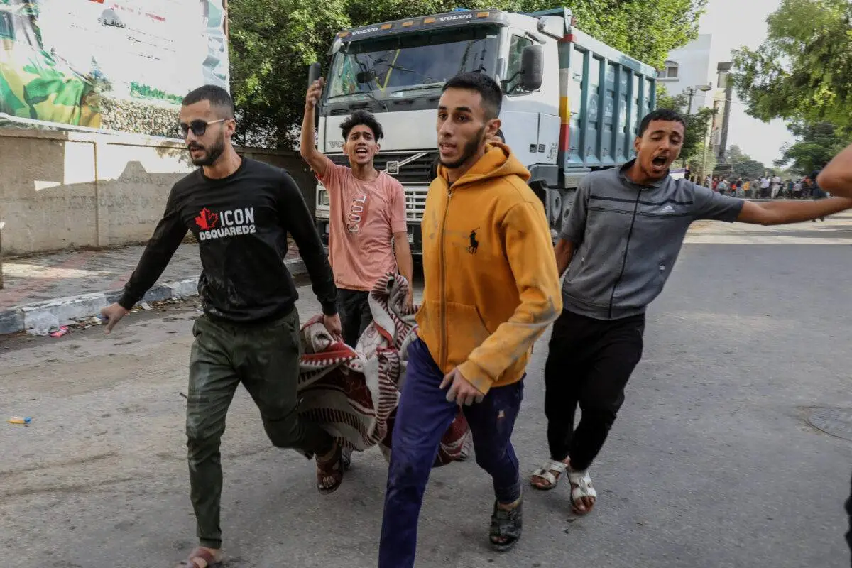 Equipes da defesa civil e residentes carregam corpos após Israel bombardear prédios civis em Rafah, na Faixa de Gaza sitiada, em 17 de outubro de 2023 [Abed Rahim Khatib/Agência Anadolu]
