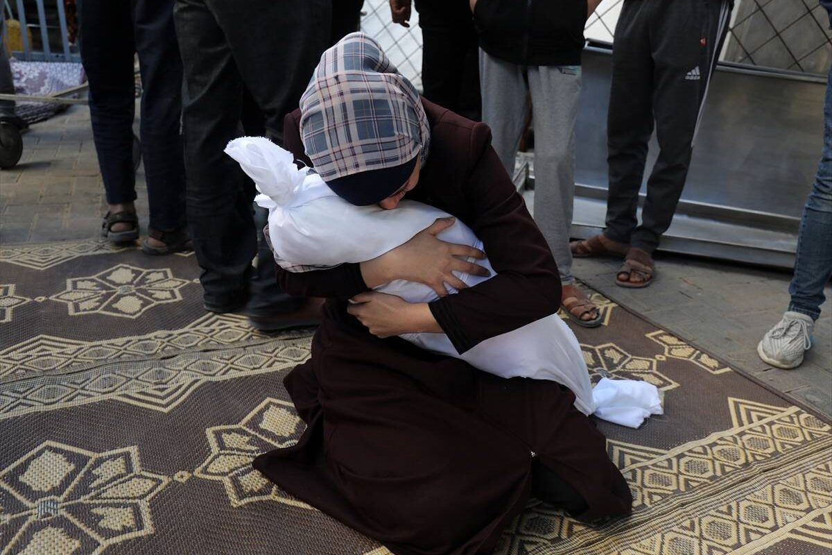 Uma mãe palestina abraça o seu filho que foi morto pelos bombardeios israelenses em Rafah, Gaza, em 21 de outubro de 2023.
[Abed Rahim Khatib/Agência Anadolu]
