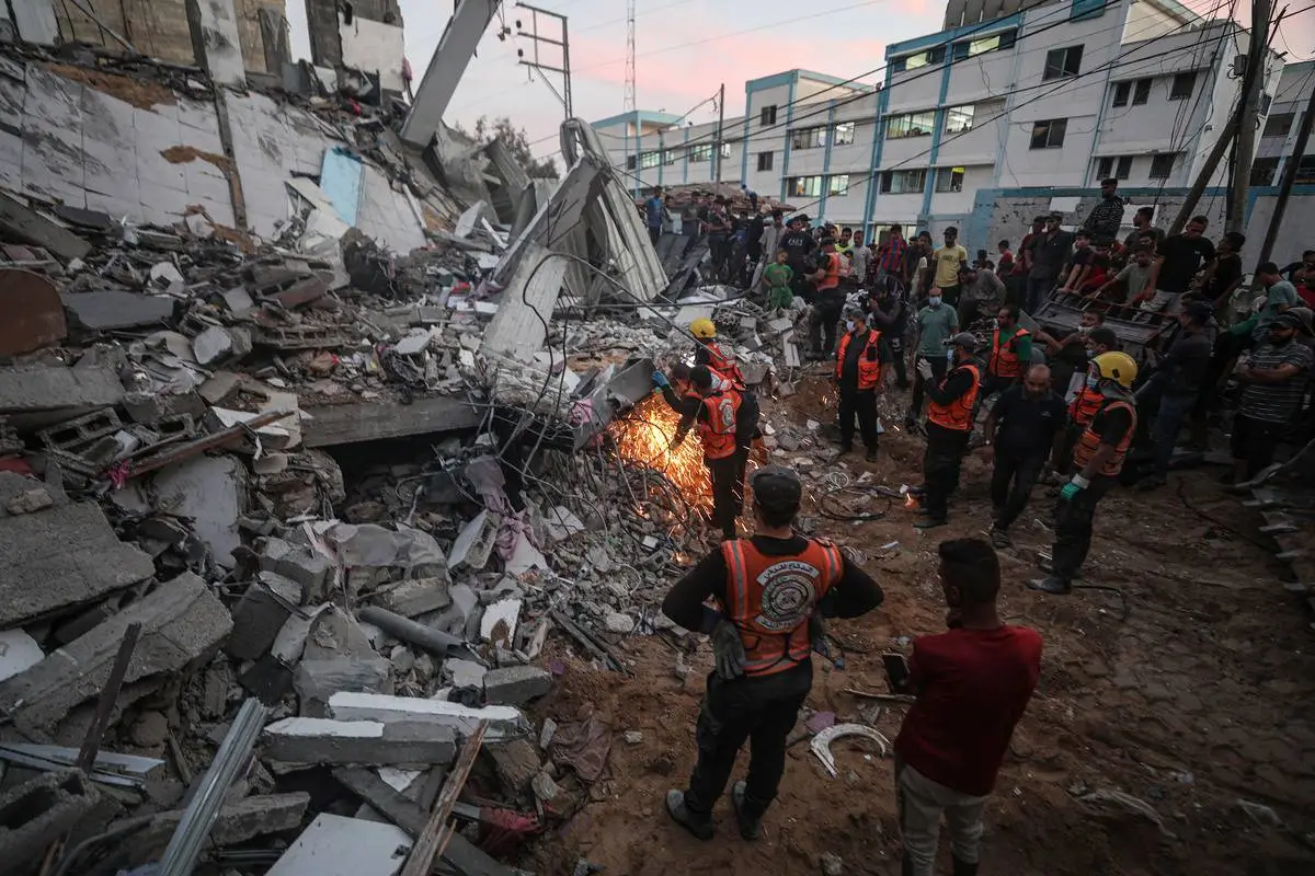 Equipes de busca e resgate participam de esforços para resgatar civis sob os escombros, após bombardeio israelense a Khan Yunis, na Faixa de Gaza, em 21 de outubro de 2023 [Mustafa Hassona/Agência Anadolu]
