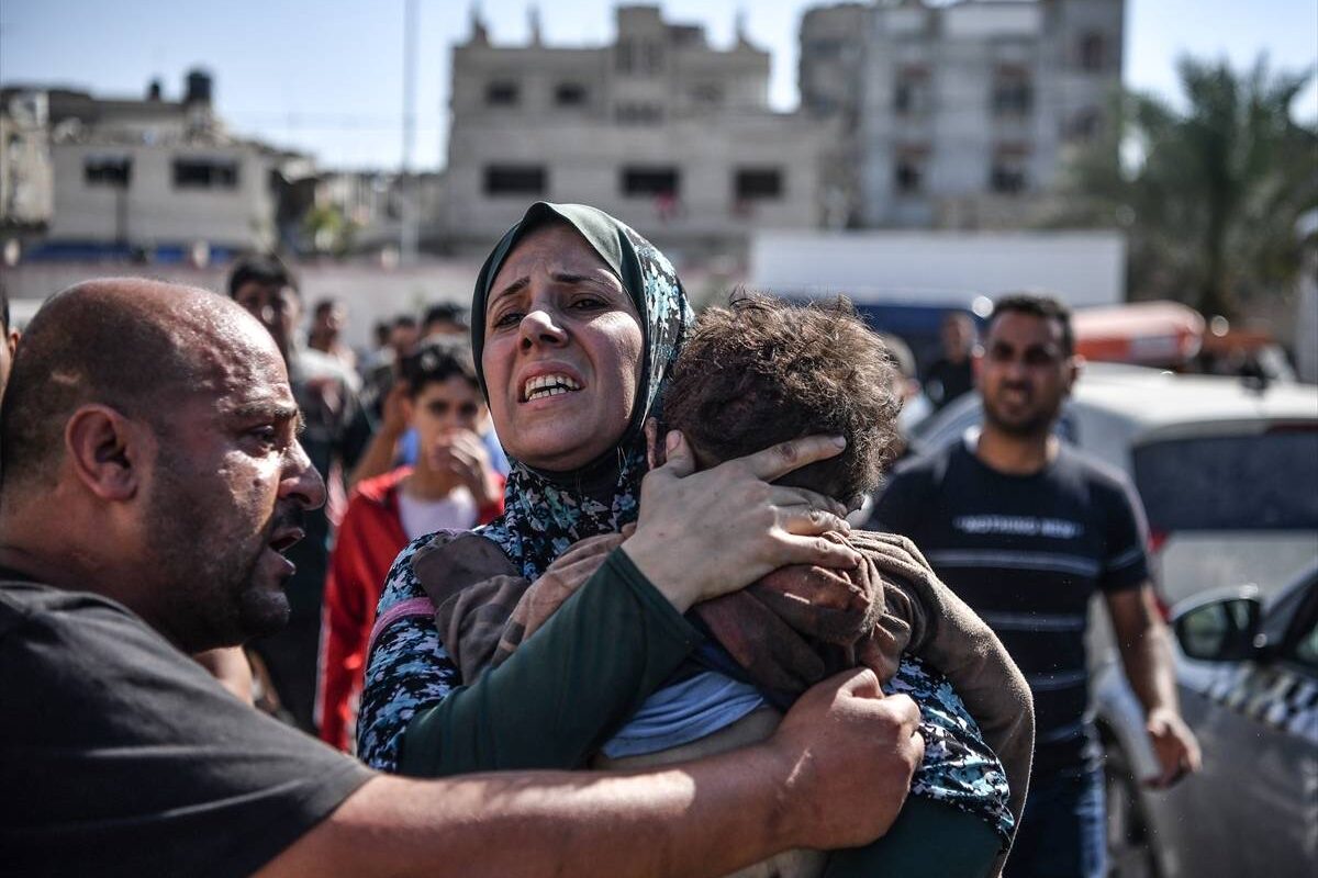 Uma mulher segura seu filho de 3 anos, Ekrem Salih Abu Shemale, que morreu após os ataques aéreos israelenses que continuam na Cidade de Gaza, Gaza, em 26 de outubro de 2023. [Abed Zagout/Agência Anadolu]
