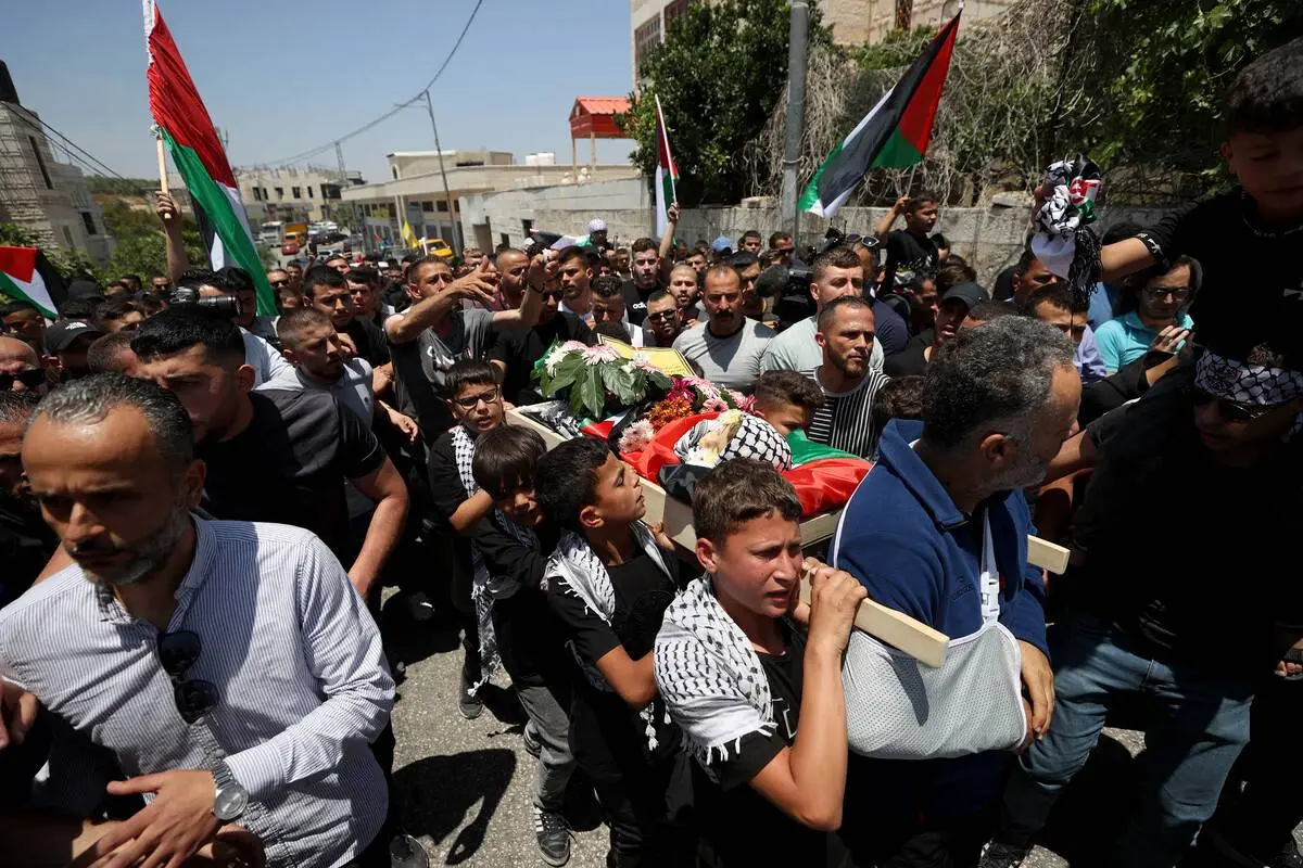 Meninos carregam o corpo de Mohammed et-Tamimi, de apenas 2 anos, morto por forças israelenses na aldeia de Nabi Saleh, a noroeste de Ramallah, na Cisjordânia ocupada, em 6 de junho de 2023 [Issam Rimawi/Agência Anadolu]
