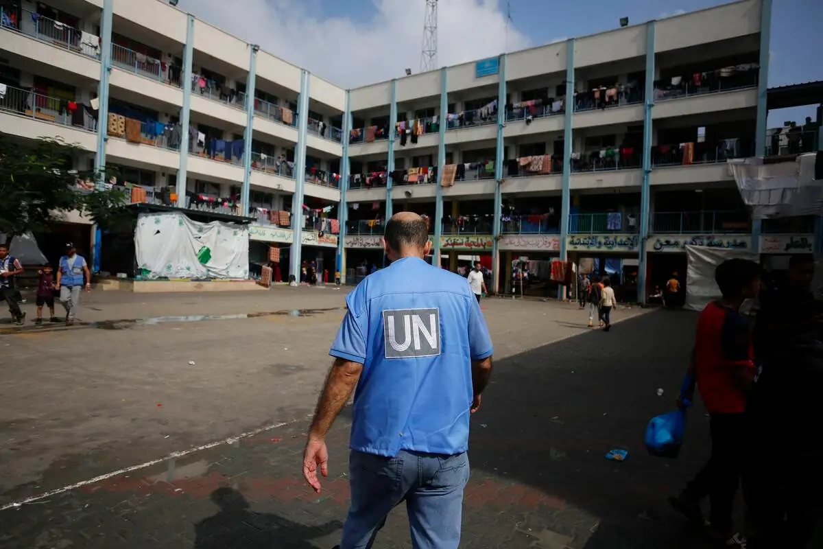 Oficiais das Nações Unidas (ONU) trabalham e distribuem ajuda às famílias palestinas, que fugiram dos ataques do exército israelense e se refugiaram em uma escola afiliada à Agência das Nações Unidas de Assistência e Obras aos Refugiados da Palestina (UNRWA) em Khan Yunis, Gaza, em 24 de outubro. 2023. [Ashraf Amra – Agência Anadolu]

