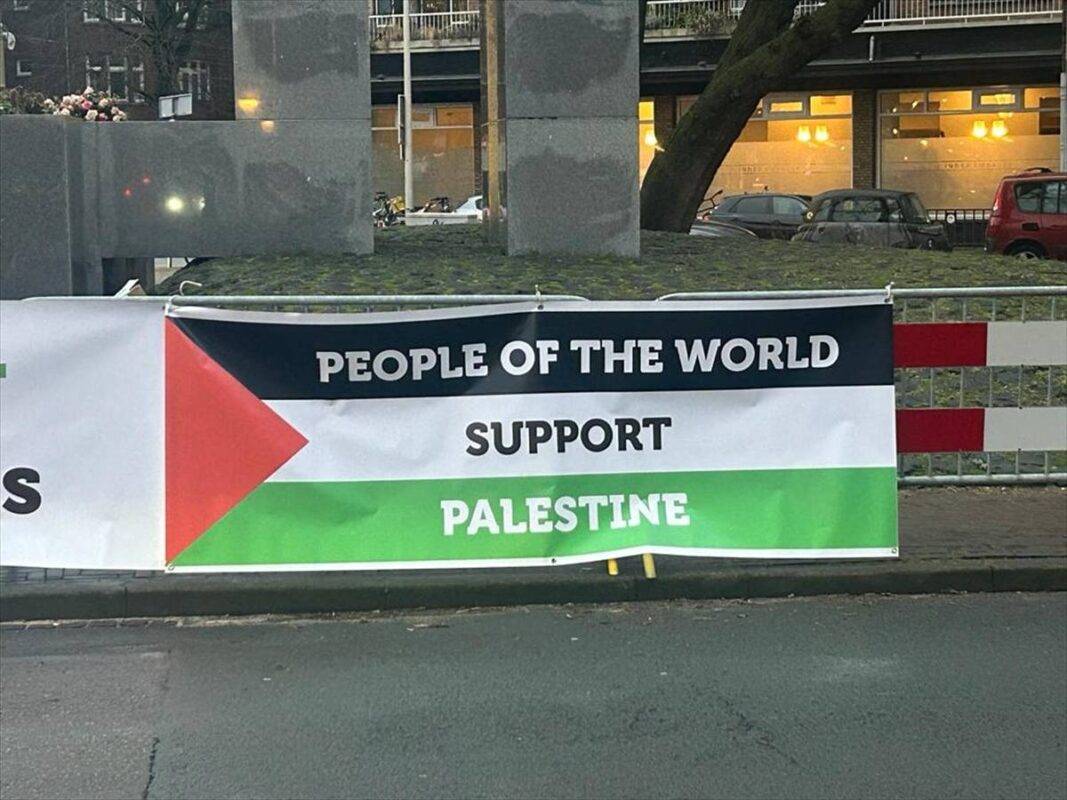 Faixas penduradas  em frente ao prédio do Tribunal Internacional de Justiça no segundo dia da audiência sobre o caso movido pela África do Sul contra Israel por supostamente cometer genocídio em Gaza em 12 de janeiro de 2024, em Haia, Holanda 
[Ahmet Gürhan Karta]