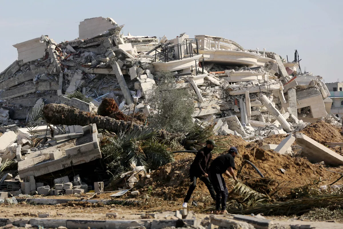 Palestinos tentam resgatar pertences dos escombros após bombardeios israelenses à região de Zawaida, em Deir al-Balah, na Faixa de Gaza, em 20 de janeiro de 2024 [Ashraf Amra/Agência Anadolu]
