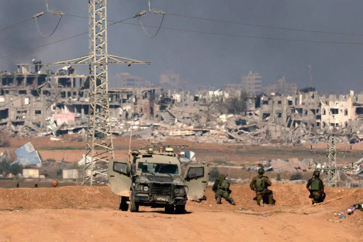 Soldados israelenses diante da destruição na Cidade de Gaza, em 1° de janeiro de 2024 [Menahem Kahana/AFP via Getty Images]
