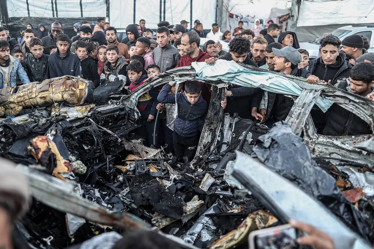 Palestinos inspecionam carro destruído por ataque israelense em Rafah, no sul de Gaza, em 7 de fevereiro de 2024 [Jehad Alshrafi/Agência Anadolu]
