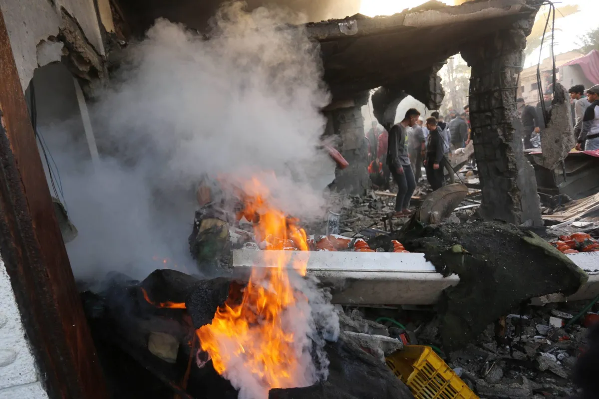 Moradores e equipes da defesa civil tentam extinguir incêndio e buscar sobreviventes após bombardeio israelense a Deir al-Balah, centro de Gaza, em 10 de fevereiro de 2024 [Ashraf Amra/Agência Anadolu]
