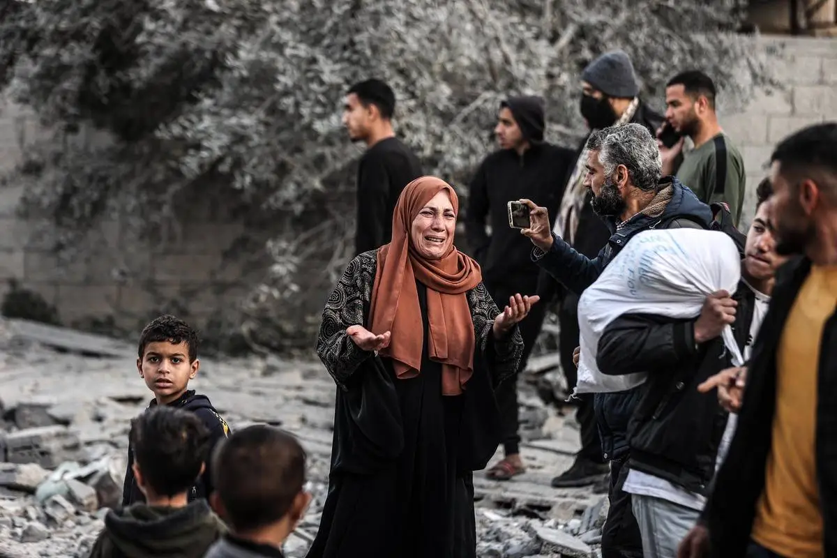 Palestinos buscam parentes e pertences após um ataque israelense à casa da família al-Kahveci, em Deir al-Balah, na Faixa de Gaza, em 12 de janeiro de 2024 [Ali Jadallah/Agência Anadolu]
