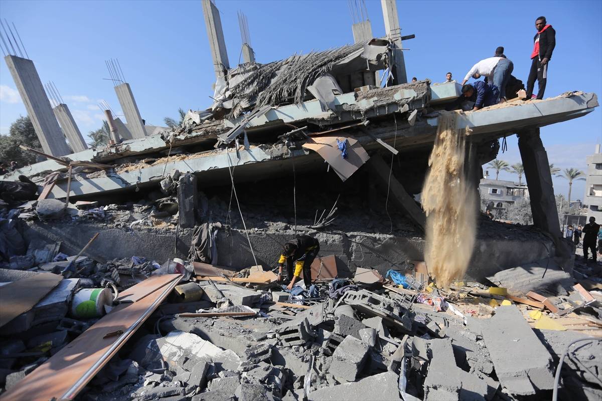 Palestinos e funcionários públicos palestinos realizam operação de busca e resgate nos escombros de um edifício residencial bombardeado por Israel  na cidade de Az-Zawayda, na Cidade de Gaza, Gaza, em 22 de fevereiro, 2024. [Ashraf Amra/Agência Anadolu]