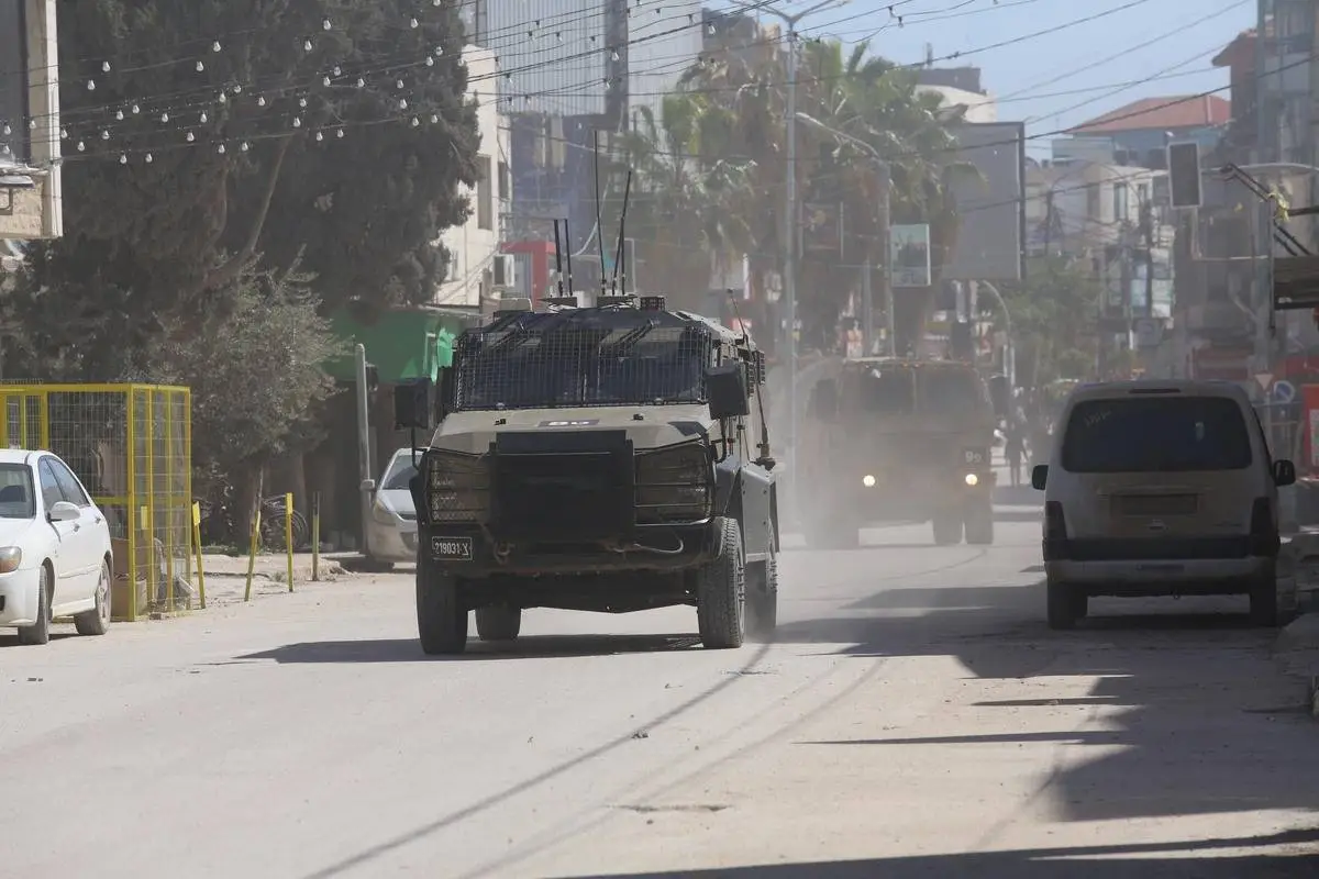 Forças israelenses, acompanhadas de veículos blindados e escavadeiras, invadem Jenin, na Cisjordânia, em 12 de março de 2024 [Nedal Eshtayah/Agência Anadolu]
