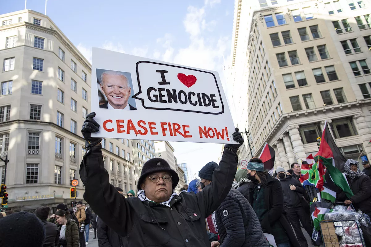 Um manifestante segura um cartaz com a foto do presidente Joe Biden e o texto "I Love Genocide, Ceasefire Now" (Eu amo o genocídio, cessar-fogo agora) enquanto participa de uma manifestação em Washington, DC, em 13 de janeiro de 2024 [Probal Rashid/LightRocket via Getty Images]
