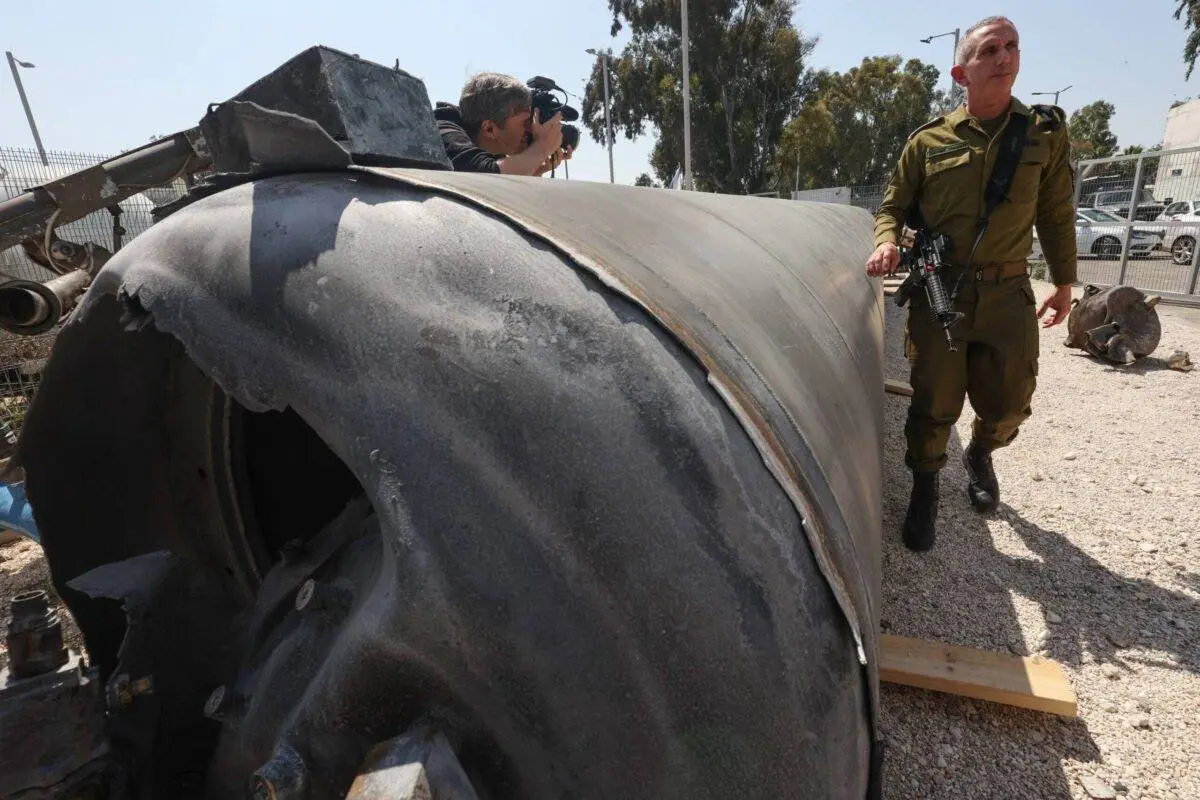 O porta-voz militar israelense, contra-almirante Daniel Hagari (dir), posa ao lado de um míssil balístico iraniano que caiu em Israel no fim de semana, durante uma visita da mídia à base militar de Julis, perto da cidade de Kiryat Malachi, no sul de Israel, em 16 de abril de 2024 [Gil Cohen-Magen/AFP via Getty Images]
