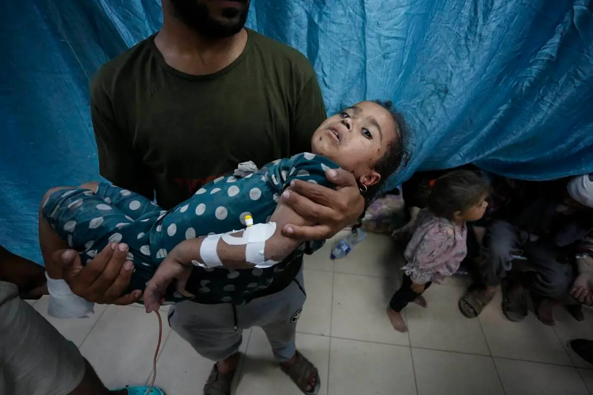 Palestinos feridos por ataques israelenses ao campo de refugiados de Nuseirat, no Hospital dos Mártires de Al-Aqsa, em Deir al-Balah, Gaza, 25 de maio de 2024 [Ashraf Amra/Agência Anadolu]
