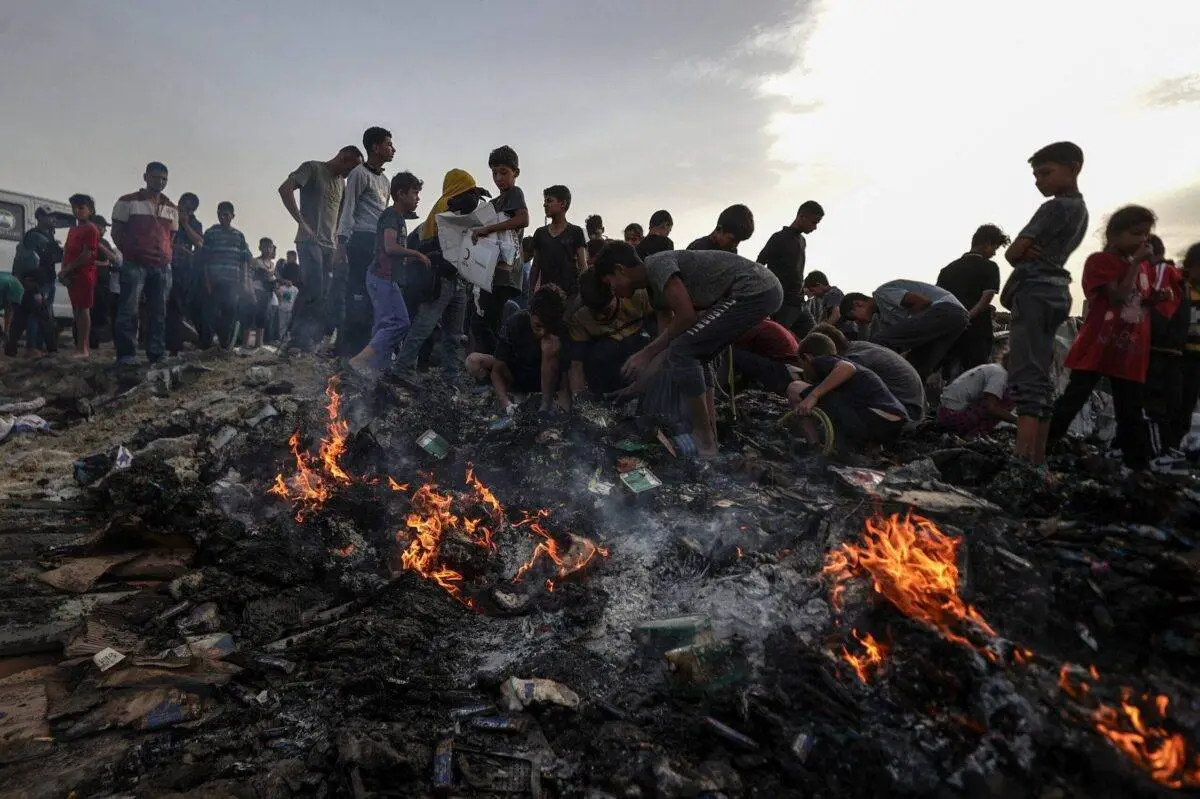 Palestinos observam a destruição causada pelos ataques do exército israelense às tendas de palestinos deslocados que vivem perto dos armazéns da Agência das Nações Unidas de Assistência aos Refugiados da Palestina (UNRWA) em Rafah, Gaza, em 27 de maio de 2024 [Ali Jadallah/Agência Anadolu]
