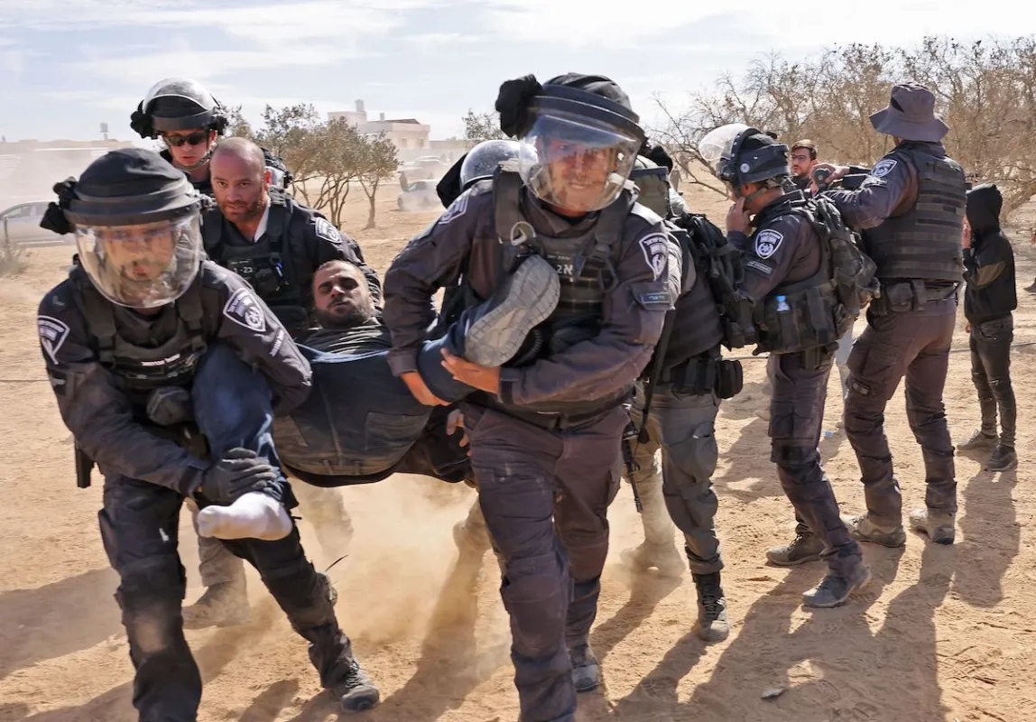 A polícia israelense detém um homem enquanto beduínos protestam na aldeia de Sawe al-Atrash, no sul de Israel, no deserto de Neguev, contra um projeto de florestamento do Fundo Nacional Judaico (JNF), [Ahmad Gharabli/AFP via Getty Images].
