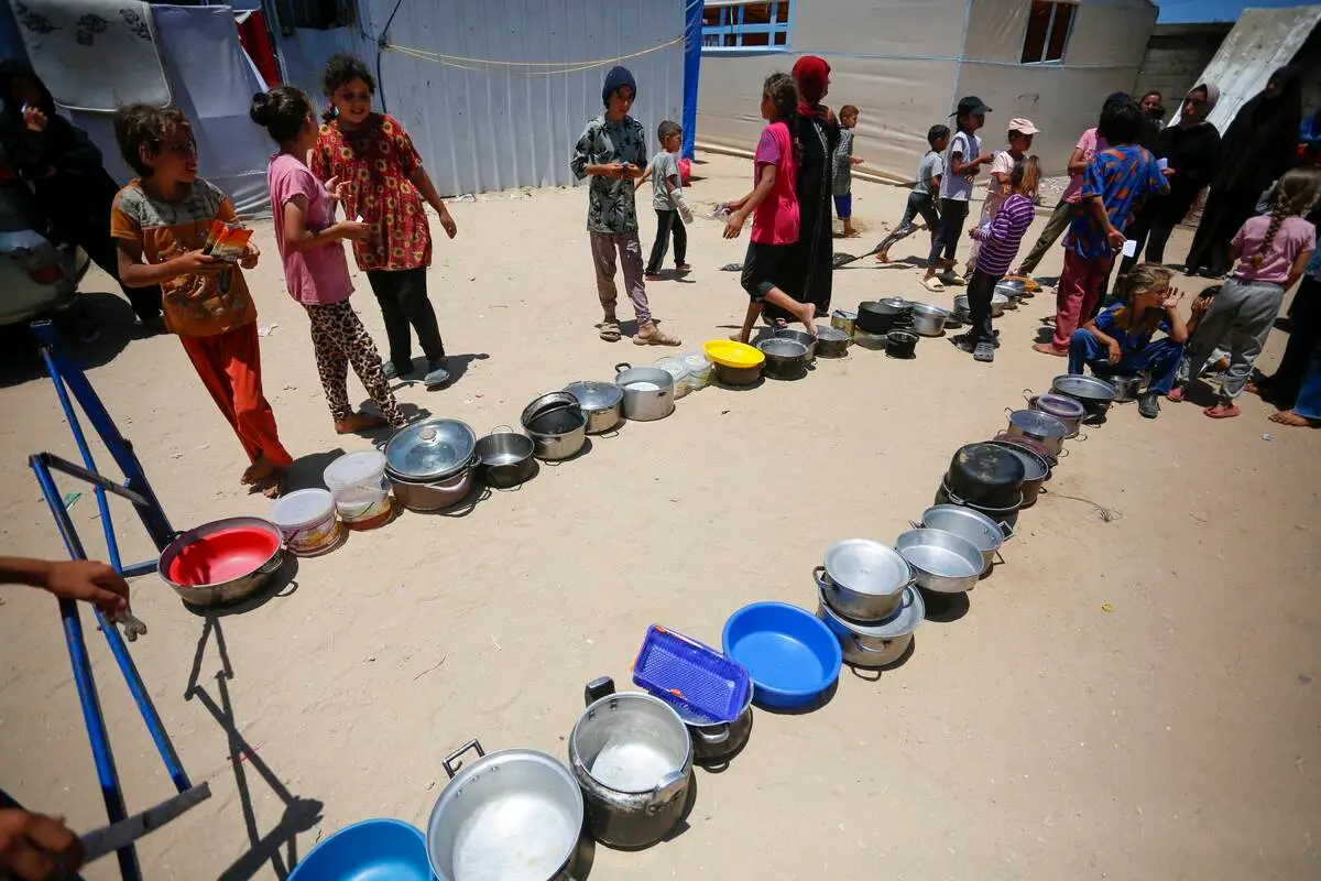 Crianças palestinas esperam para receber a ajuda distribuída, em Deir al-Balah, Gaza, em 30 de junho de 2024 [Ashraf Amra/ Anadolu Agency]
