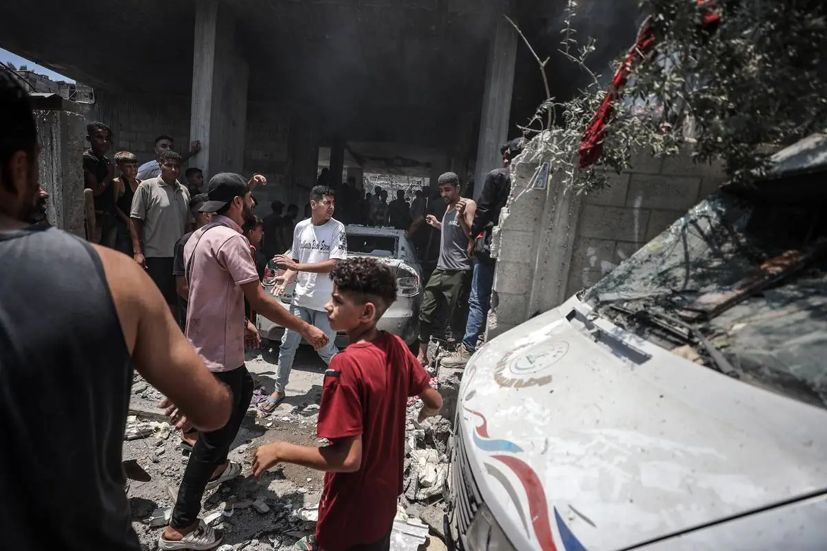 Equipes de defesa civil e palestinos apagam o fogo depois que ataques aéreos israelenses atingiram um prédio residencial em Deir al Balah, Gaza, em 15 de julho de 2024 [Ali Jadallah - Agência Anadolu].
