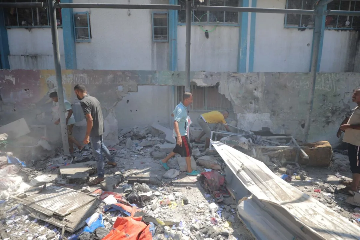 Palestinos inspecionam uma escola danificada depois que caças israelenses atingiram a escola da Agência das Nações Unidas de Assistência aos Refugiados da Palestina no Oriente Próximo (UNRWA), matando e ferindo muitas pessoas no Campo de Refugiados de Nuseirat, em Deir al-Balah, Gaza, em 15 de julho de 2024 [Hassan Jedi/Anadolu Agency]
