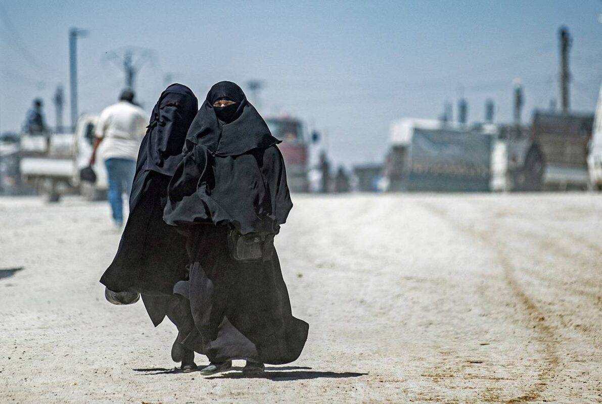 Mulheres caminham no campo de refugiados de al-Hol, que abriga familiares de combatentes do grupo terrorista Daesh (Estado Islâmico), no nordeste da Síria, em 11 de maio de 2021 [Delil Souleiman/AFP via Getty Images]

