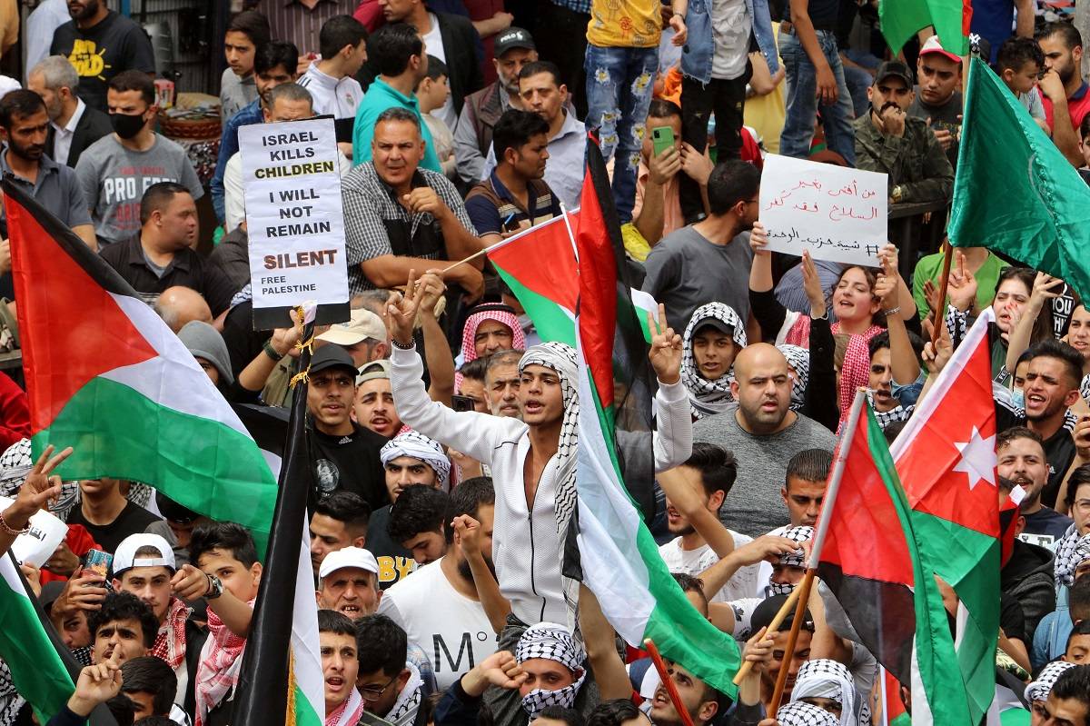 Manifestantes erguem bandeiras da Palestina e da Jordânia, bem como cartazes, enquanto marcham nas ruas de Amã, capital da Jordânia, em 22 de abril de 2022, para demonstrar solidariedade aos palestinos em Jerusalém, em meio ao aumento das tensões entre eles e as forças israelenses no complexo da mesquita de Al-Aqsa. [AFP via Getty Images]
